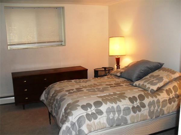 12 Bryon Road, Unit 1 Chestnut Hill, MA 02467 - Photo 5 of 8 a bedroom with a bed and a lamp