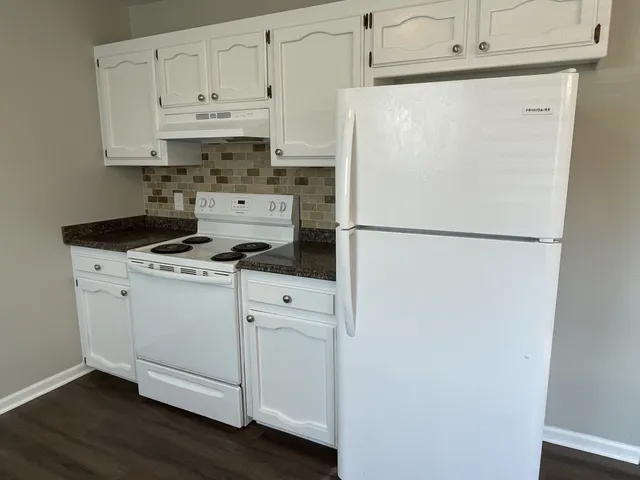 a white refrigerator freezer and a stove sitting inside of a kitchen