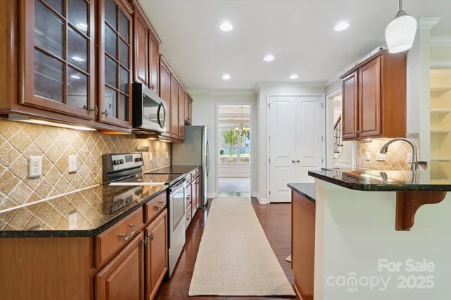 a kitchen with stainless steel appliances granite countertop a sink and stove