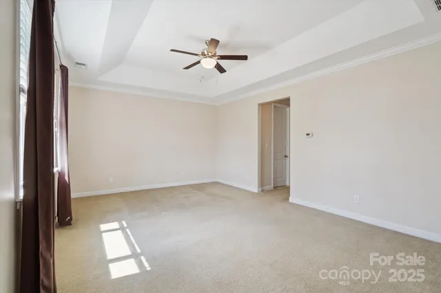 an empty room with ceiling fan and window