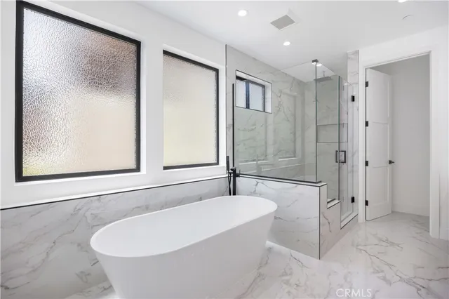 a bedroom with a bed and a large window with balcony view