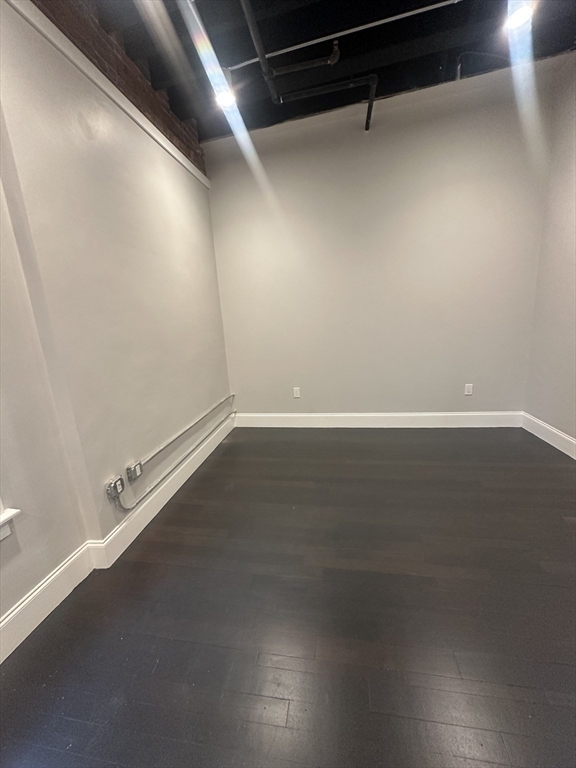 281 Franklin Street, Unit 602 Boston, MA 02110 - Photo 5 of 10 an empty room with wooden floor and windows