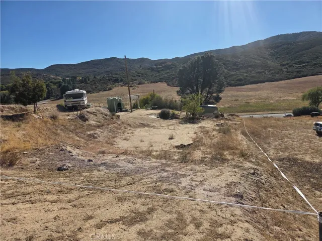a view of a dry yard with mountains in the background
