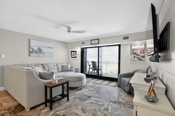 a living room with furniture a flat screen tv and a large window