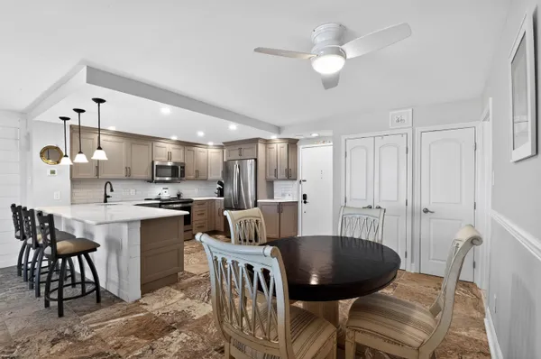 a kitchen with a dining table chairs and white cabinets
