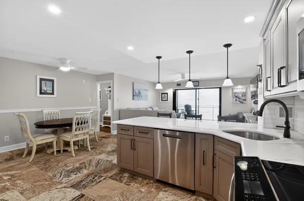 a kitchen with kitchen island a dining table chairs sink and stove