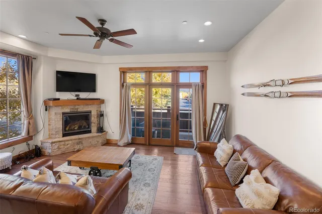 a living room with furniture a flat screen tv and a fireplace