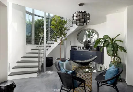 a view of a dining room with furniture a potted plant and a chandelier