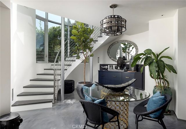 a view of a dining room with furniture a potted plant and a chandelier