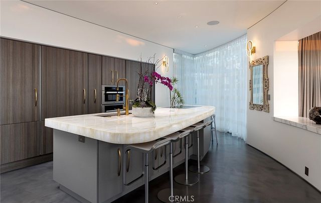 a kitchen with stainless steel appliances kitchen island a table chairs in it and wooden floors