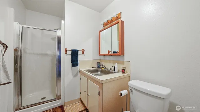 a bathroom with a sink a toilet and shower