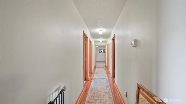 a view of a hallway with wooden floor and staircase