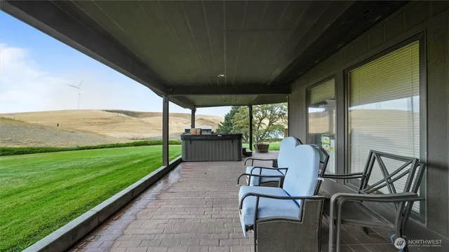 a patio with table and chairs and potted plants