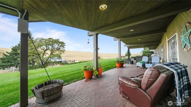 a view of a patio with couches chairs and a yard