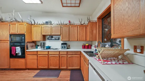 a kitchen with a sink dishwasher a stove and a refrigerator with wooden floor