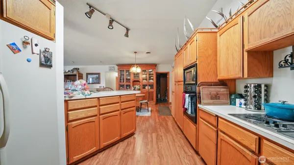 a large kitchen with stainless steel appliances granite countertop a lot of counter space and wooden floors