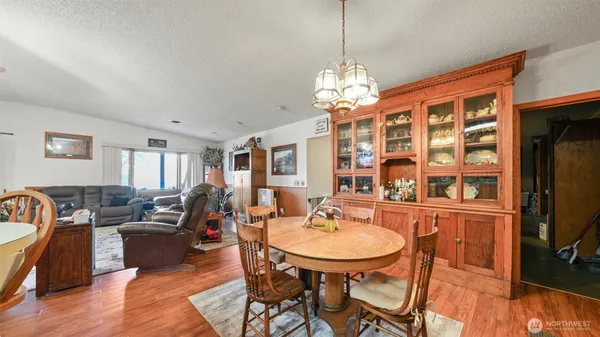 a view of a dining room with furniture a chandelier and wooden floor