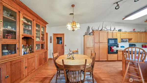 a dining room with furniture a chandelier and wooden floor