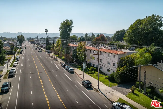 a view of a city street with couple of cars parked on road
