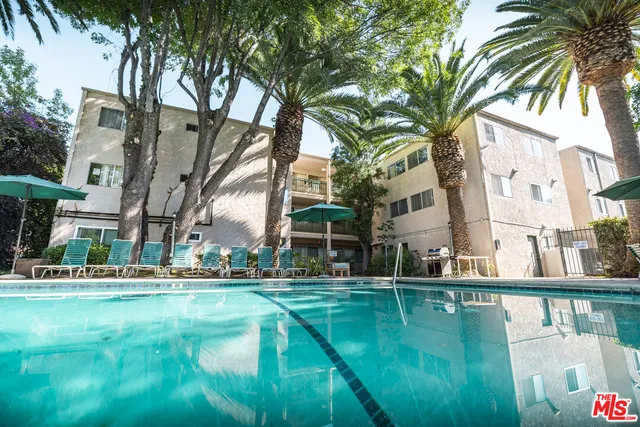 a view of a house with a yard and potted plants