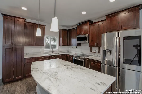 a kitchen with kitchen island a counter top space appliances and cabinets
