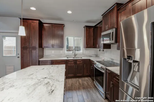 a kitchen with stainless steel appliances granite countertop a refrigerator stove a sink and dishwasher