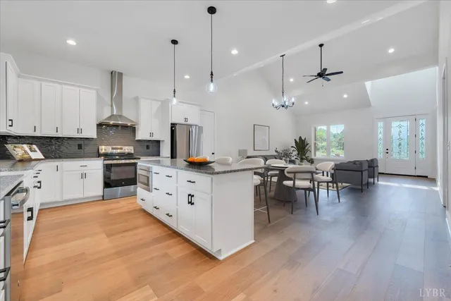 a kitchen with stainless steel appliances kitchen island wooden floors stove center island and cabinets
