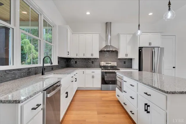 a large kitchen with stainless steel appliances granite countertop a sink a stove and a refrigerator