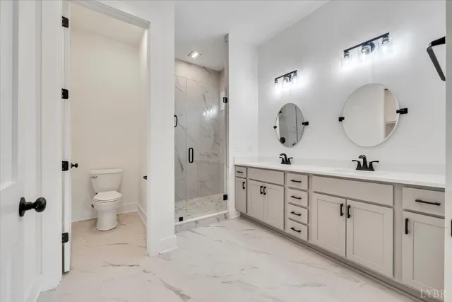 a spacious bathroom with a double vanity sink toilet and shower