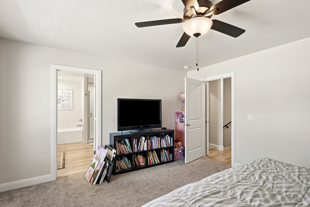 668 East Fiddlers Canyon Road, Unit 6 Cedar City, UT 84721 - Photo 16 of 36 Neutral wall paint, ceiling fan with integrated lighting, wood-finish flooring in the doorway, and carpeted area