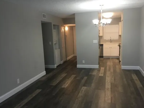 a view of a room with wooden floor and a bathroom