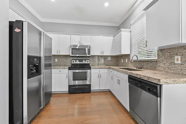 a kitchen with kitchen island granite countertop stainless steel appliances and sink