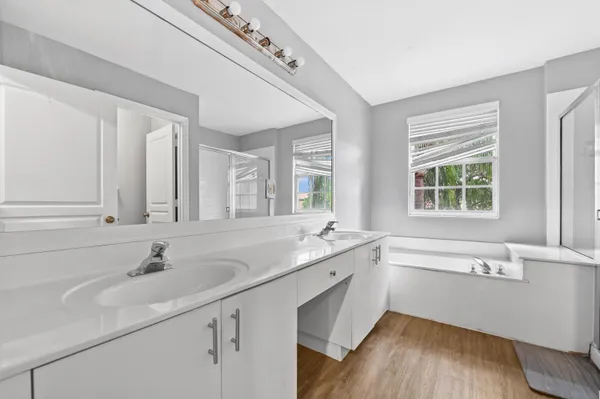 a bathroom with a tub sink and mirror