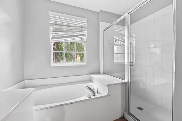 a white bath tub sitting next to a shower