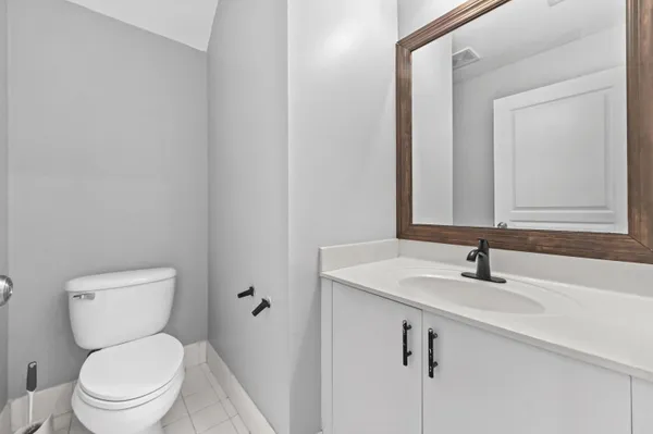 a bathroom with a toilet a sink and mirror