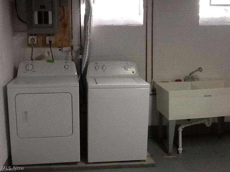 9750 Snow Road Cleveland, OH 44130 - Photo 20 of 24 Basement laundry/utility room with utility Sink, updated Electric panel (2014), newer washer and dryer (2014) will stay. Also basement commode - unseen in picture is located at lower level.
