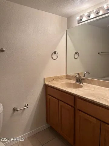 a bathroom with a granite countertop sink a mirror and a toilet