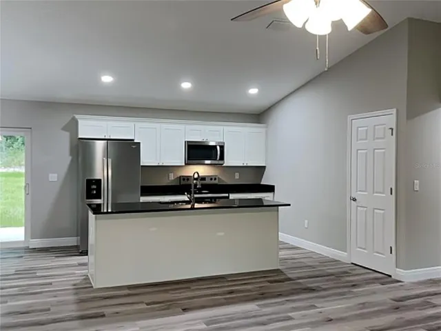 a kitchen with stainless steel appliances granite countertop a sink and a stove
