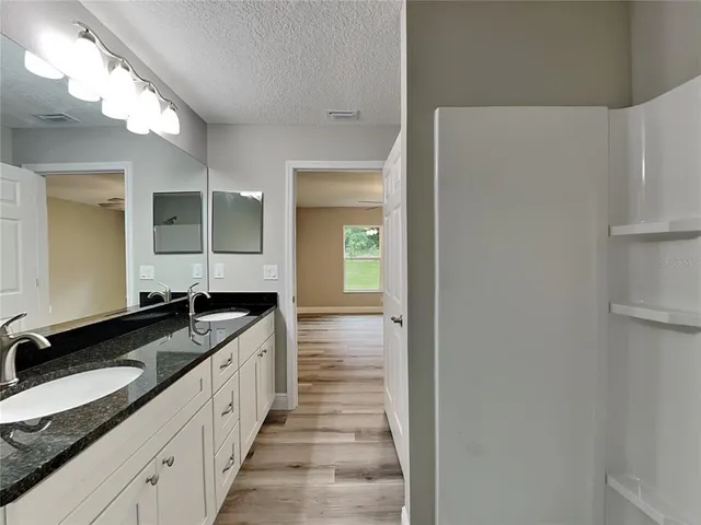 a large bathroom with a granite countertop sink and a mirror