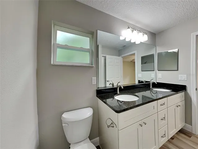 a bathroom with a granite countertop sink and a mirror