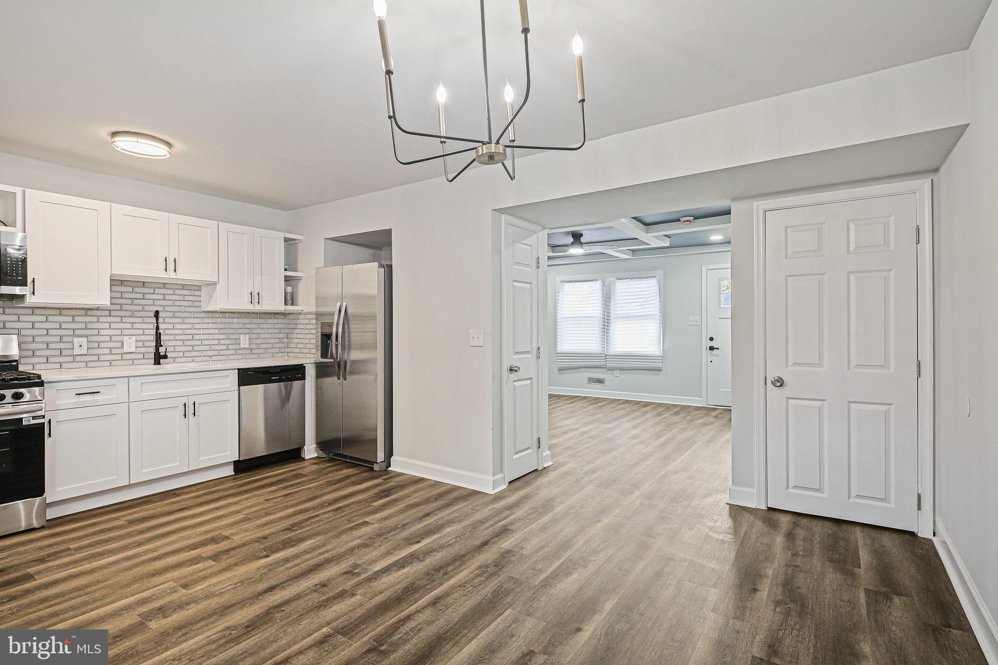 4702 Vancouver Road Baltimore, MD 21229 - Photo 11 of 33 a view of a kitchen with a sink and dishwasher a refrigerator with wooden floor