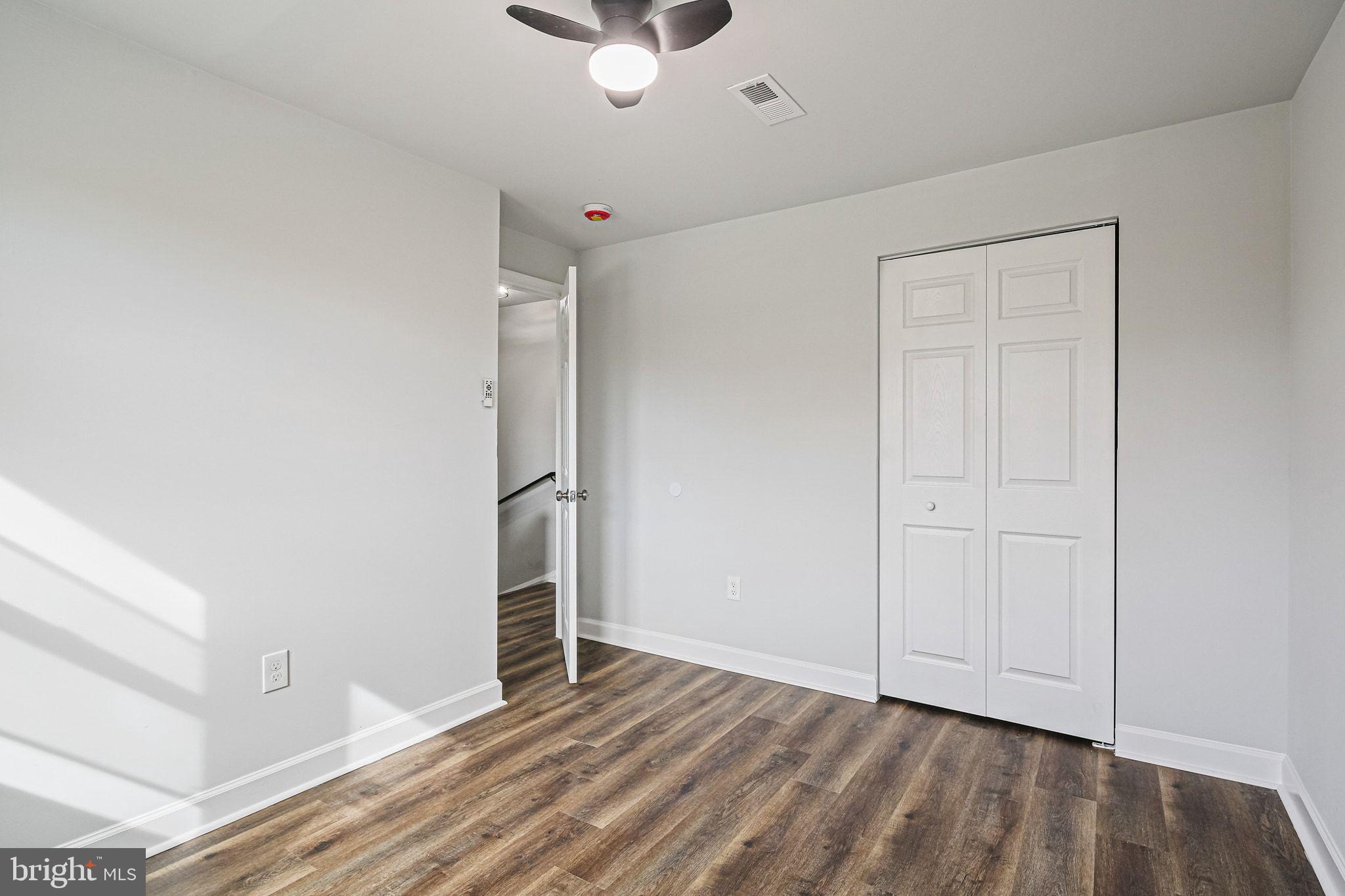 4702 Vancouver Road Baltimore, MD 21229 - Photo 15 of 33 an empty room with wooden floor cabinet and windows
