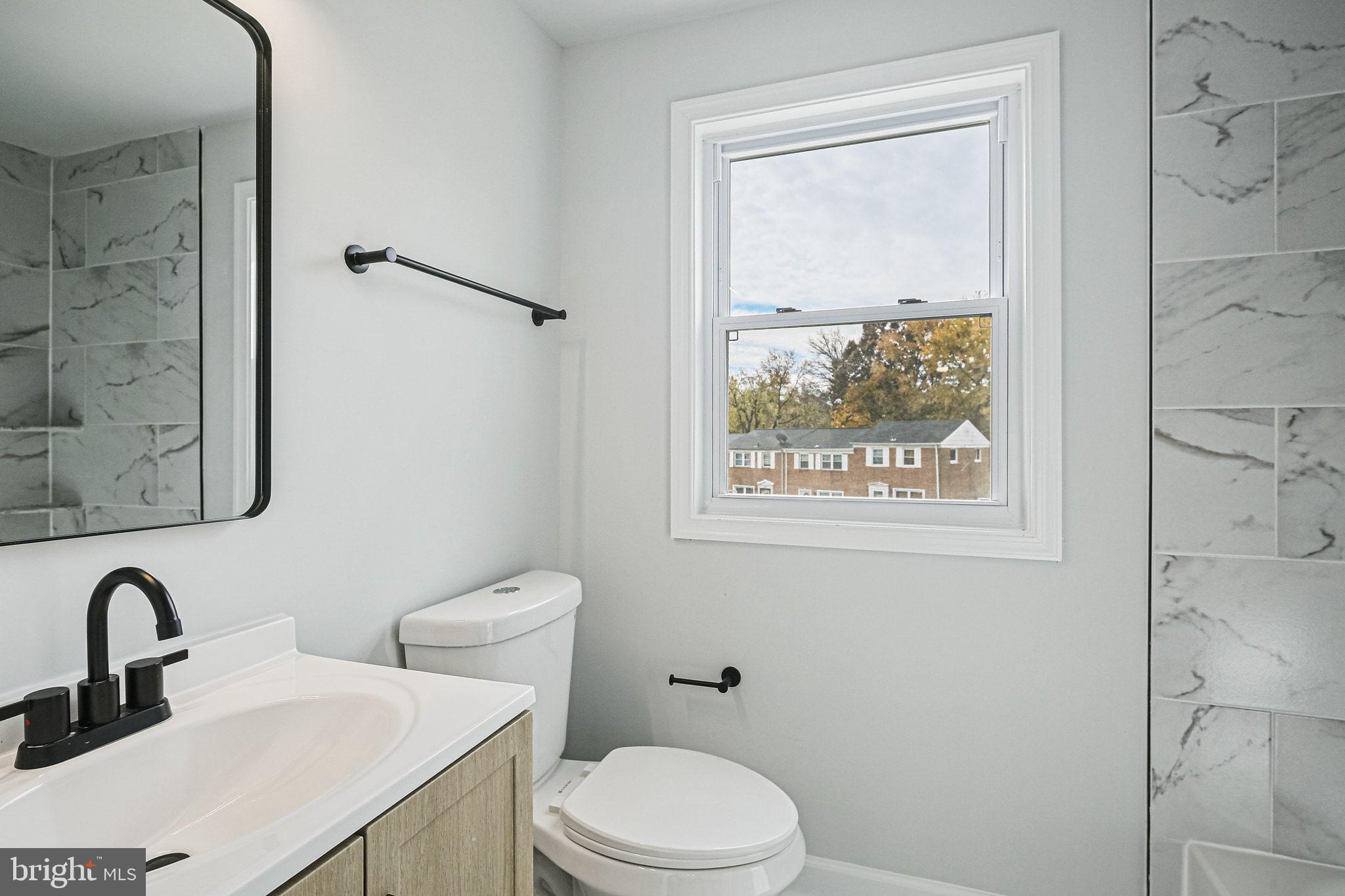 4702 Vancouver Road Baltimore, MD 21229 - Photo 17 of 33 a bathroom with a toilet a sink and mirror
