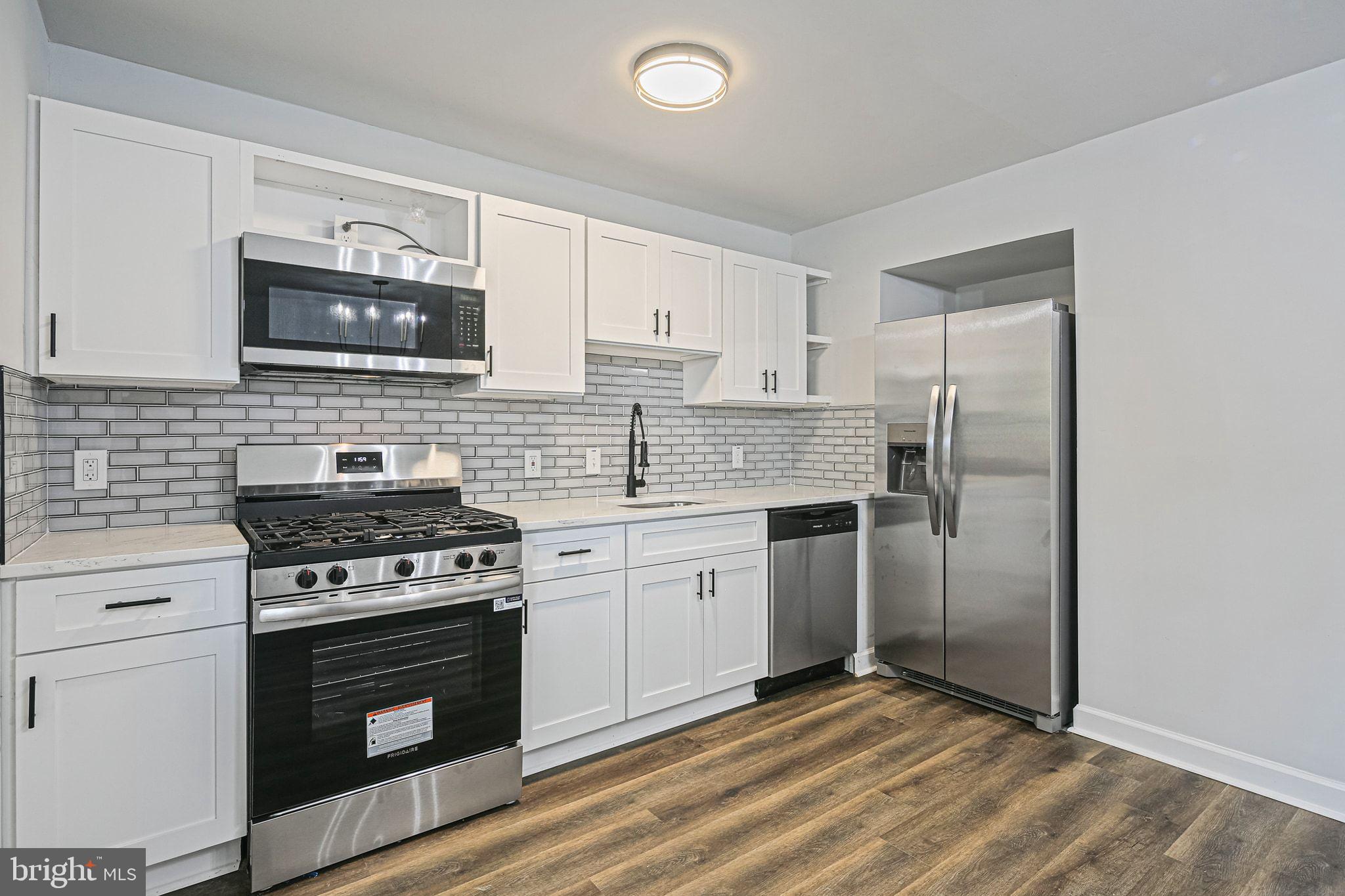 4702 Vancouver Road Baltimore, MD 21229 - Photo 8 of 33 a kitchen with granite countertop a stove sink and refrigerator