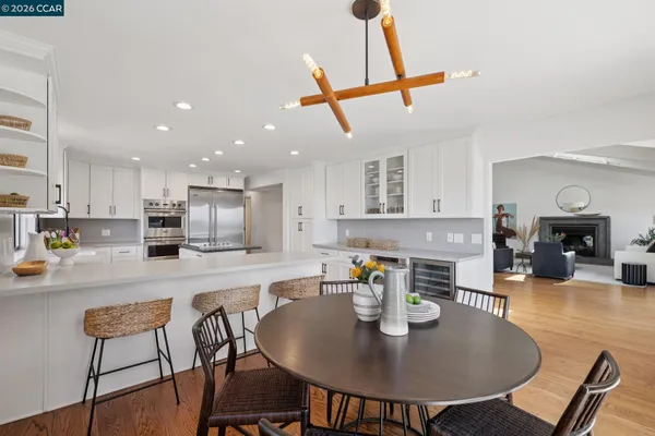 a kitchen with stainless steel appliances kitchen island granite countertop a dining table chairs and stove top oven with wooden floor