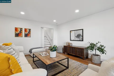 a living room with furniture flowerpot and wooden floor