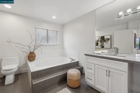 a bathroom with a granite countertop sink and a toilet