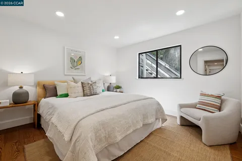 a bedroom with bed and a painting on the wall