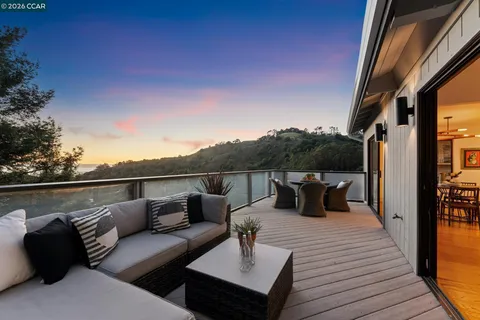 an outdoor sitting area with furniture and wooden floor