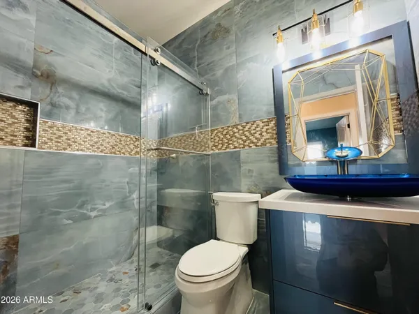 a bathroom with a sink a toilet and shower